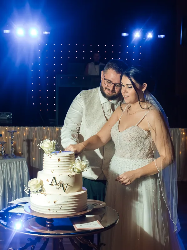 Brautpaar beim Anschneiden der Hochzeitstorte auf der abendlichen Feier.