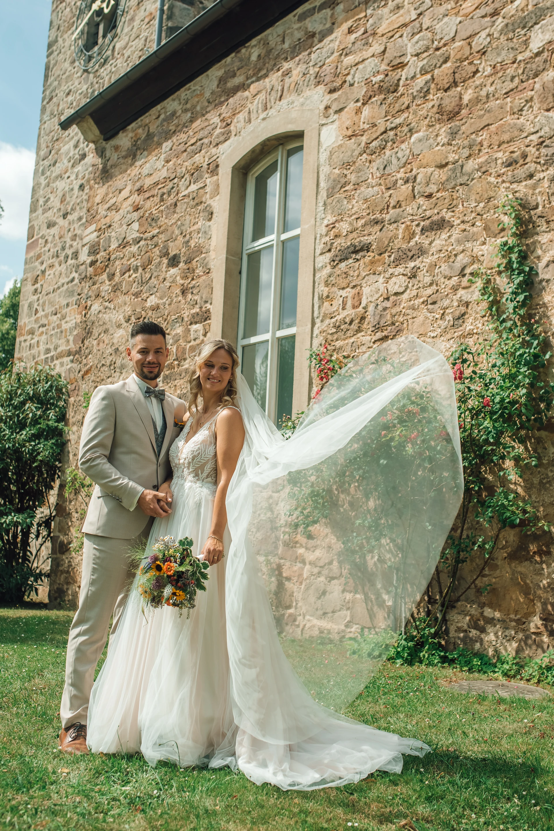 Ganzkörperportrait von Sarah und Tobias vor der Kirche in Sandershausen